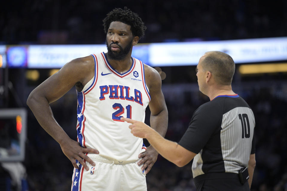 Official John Goble (10) explains a call to Philadelphia 76ers center Joel Embiid (21) during the first half of an NBA basketball game against the Orlando Magic, Friday, Jan. 19, 2024, in Orlando, Fla. (AP Photo/Phelan M. Ebenhack)