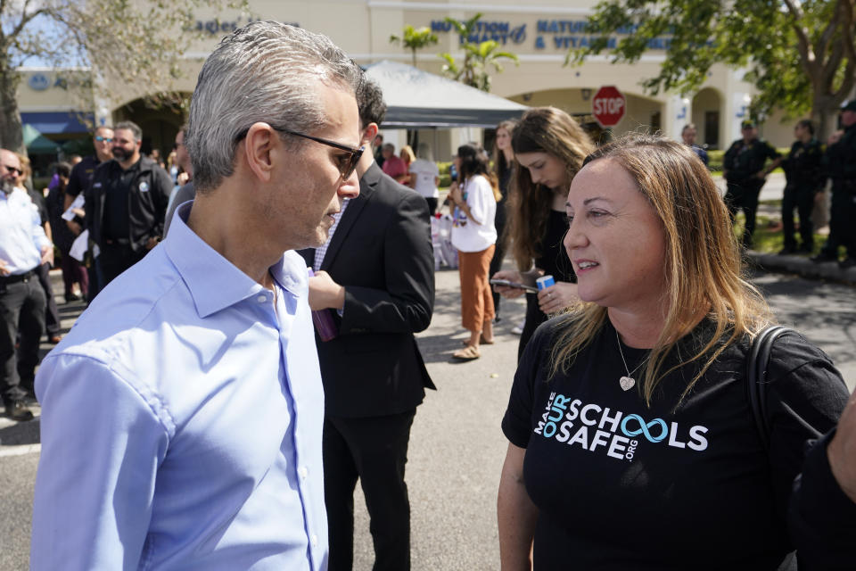 Max Schachter, left, father of shooting victim Alex Schachter, and Lori Alhadeff, mother of shooting victim Alyssa Alhadeff, talk, Tuesday, Feb. 14, 2023, at a ceremony in Coral Springs, Fla., honoring the lives of the 17 students and staff of Marjory Stoneman Douglas High School that were killed on Valentine's Day, 2018. (AP Photo/Wilfredo Lee)