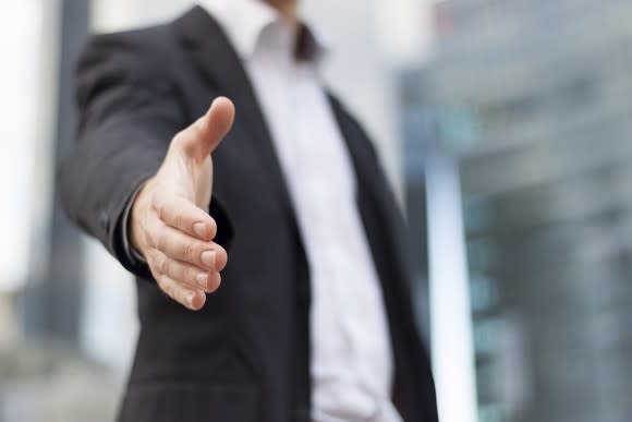 Man in suit extending a handshake