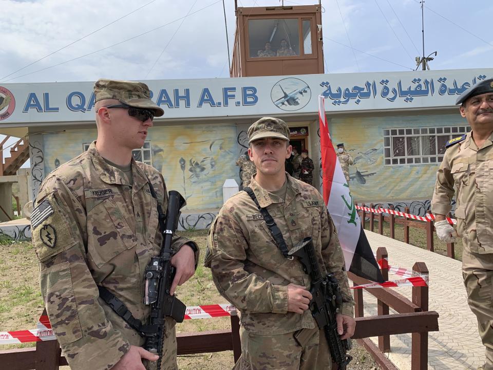 FILE - In this March 27, 2020 file photo, U.S. soldiers stand guard during the hand over ceremony of Qayyarah Airfield, Iraqi Security Forces, in the south of Mosul, Iraq. In a quest to root out Islamic State group hideouts over the summer, Iraqi forces on the ground cleared nearly 90 villages across a notoriously unruly northern province. But the much-touted operation still relied heavily on U.S. intelligence, coalition flights and planning assistance. (AP Photo/Ali Abdul Hassan, File)