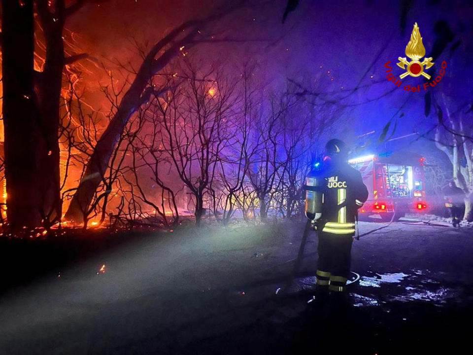 Firefighters work to extinguish a wildfire burning near the Sicilian village of Curcuraci near Messina, Italy, July 25, 2023. Vigili del Fuoco/Handout via REUTERS ATTENTION EDITORS THIS IMAGE HAS BEEN SUPPLIED BY A THIRD PARTY. DO NOT OBSCURE LOGO.