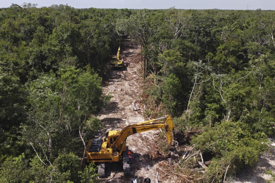 A bulldozer sits idle during repairs as it clears a path through the forest to make way for the Maya Train project in Akumal, Quintana Roo state, Mexico, Tuesday, Aug. 2, 2022. The Maya Train is one of Mexican President Andrés Manuel López Obrador’s signature projects and has drawn objections from environmentalists, archaeologists and cave divers, who have held protests to block backhoes from tearing down trees and scraping clean the thin layer of soil. (AP Photo/Eduardo Verdugo)