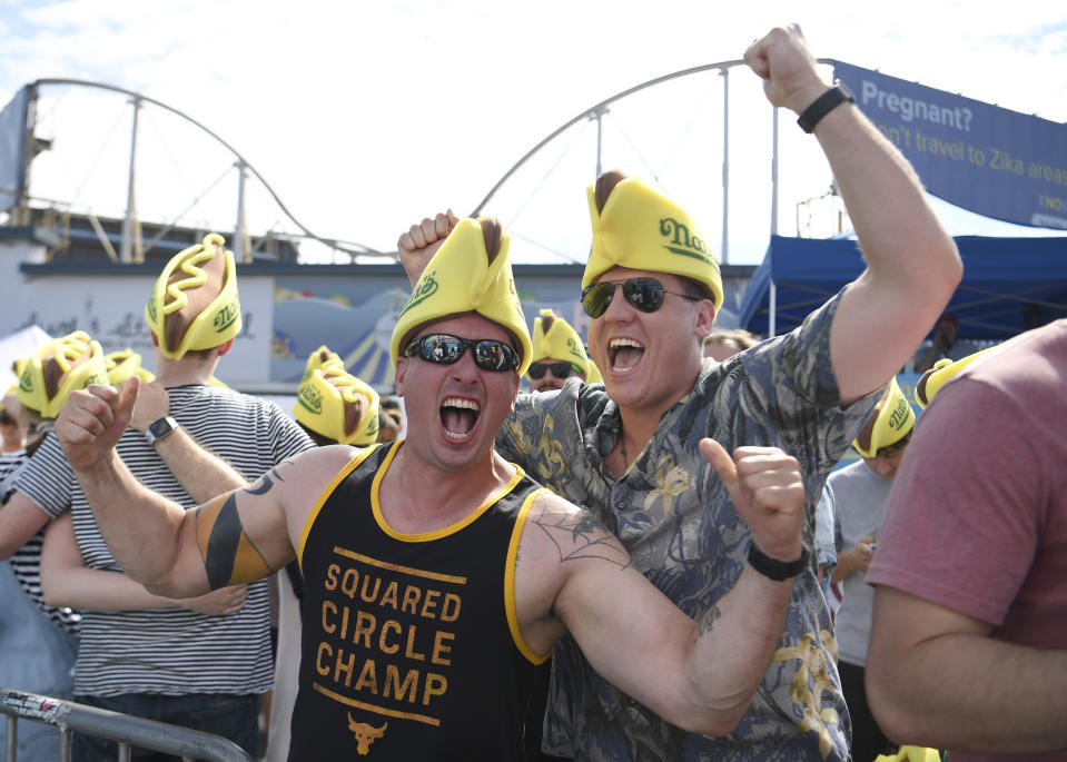 George Cartolano, left, cheers with Justin Ruger, right, before the annual Nathan's Famous July Fourth hot dog eating contest, Thursday, July 4, 2019, in New York's Coney Island. (AP Photo/Sarah Stier)