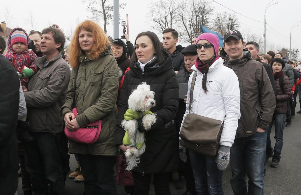 People wait to enter Ukrainian President Yanukovych's countryside residence in Mezhyhirya, Kiev's region, Ukraine, Saturday, Feb, 22, 2014. Viktor Yanukovych is not in his official residence of Mezhyhirya, which is about 20 km (12.5 miles) north of the capital. Ukrainian security and volunteers from among Independence Square protesters have joined forces to protect the presidential countryside retreat from vandalism and marauding. Yanukovych left Kiev for his support base in the country's Russian-speaking east, but an aide said that he has no intention of abandoning power. (AP Photo/Efrem Lukatsky)