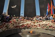 People lay flowers at a monument in Yerevan on April 24, 2014, that is dedicated to Armenians killed by Ottoman Turks during World War I