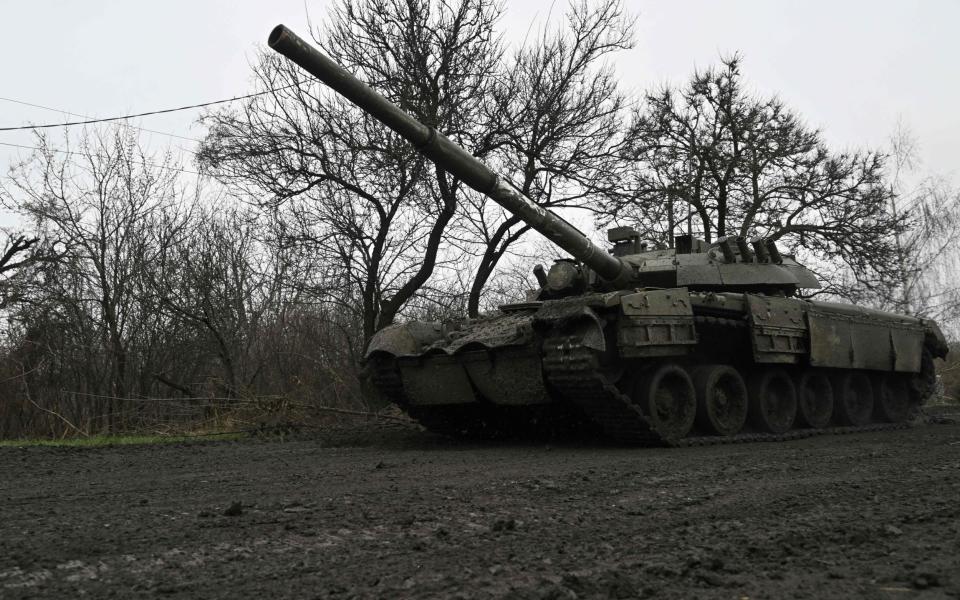 A Ukrainian tank rolls on a muddy road near Bakhmut - GENYA SAVILOV/AFP