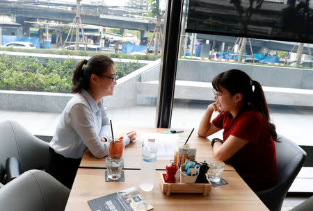 Chinese national Cherry He Ting (L) teaches a student in a coffee shop in Bangkok, Thailand, November 18, 2018. Picture taken November 18, 2018. REUTERS/Soe Zeya Tun