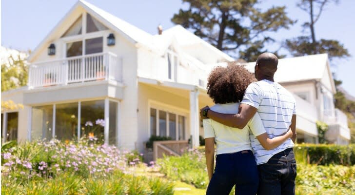 Couple standing outside a house they just bought