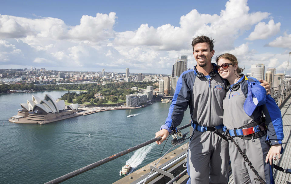 In this photo released by Destination NSW, Arizona Diamondbacks infielder Cliff Pennington poses with his wife after climbing the Sydney Harbour Bridge in Sydney Thursday, March 20, 2014. The Diamondbacks will play the Los Angeles Dodgers in their Major League Baseball season opening games at the Sydney Cricket Ground on Saturday and Sunday. (AP Photo/Destination NSW, James Horan)