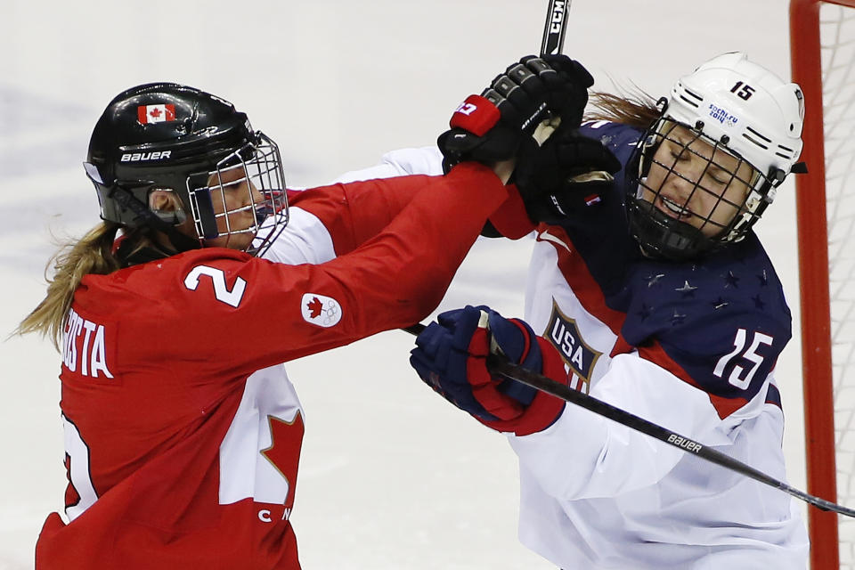 Meghan Agosta-Marciano of Canada (2) and Anne Schleper of the United States (15) mix it up during the second period of the women's gold medal ice hockey game at the 2014 Winter Olympics, Thursday, Feb. 20, 2014, in Sochi, Russia. (AP Photo/Petr David Josek)