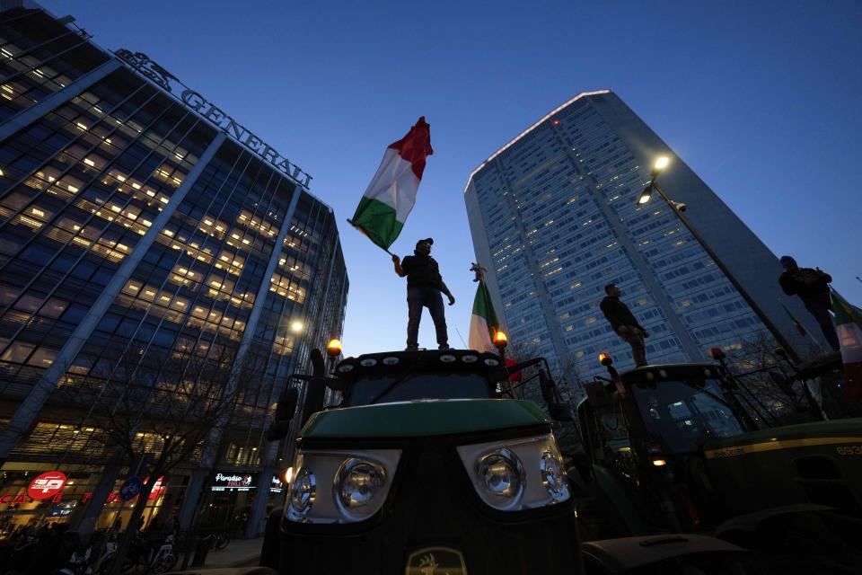 Farmers gather with their parked tractors to protest in from of the Pirelli skyscraper Lombardy region headquarter, in Milan, Italy, Thursday, Feb. 1, 2024. Farmers have been protesting in various parts of Italy and Europe against EU agriculture policies. (AP Photo/Luca Bruno)