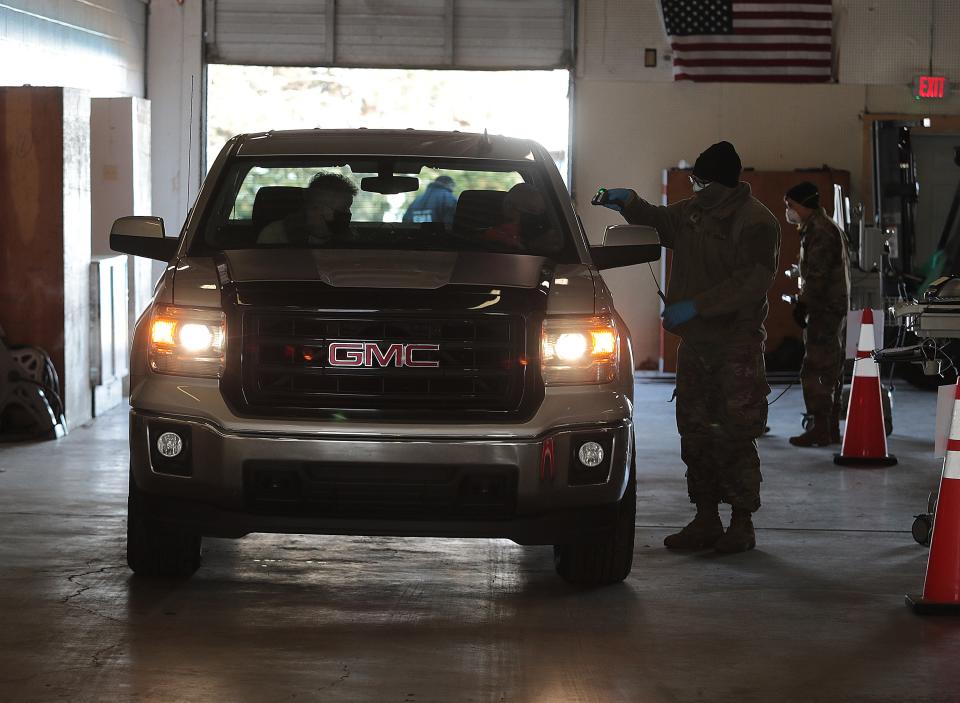 An Ohio National Guardsman checks a couple for COVID-19 last week at the Stark County Fairgrounds.