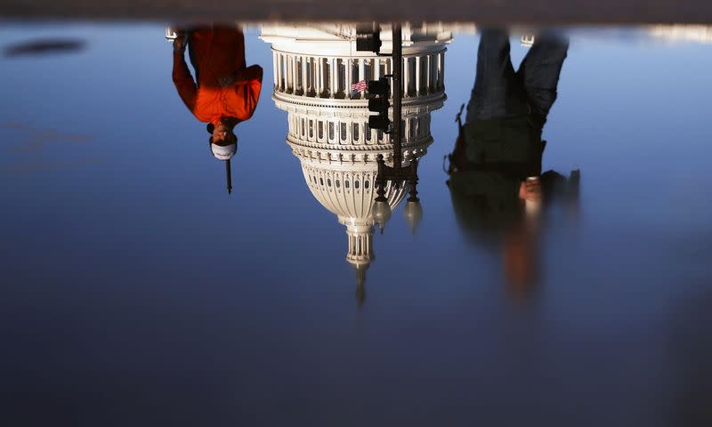 U.S. Capitol is seen reflected in a puddle in Washington