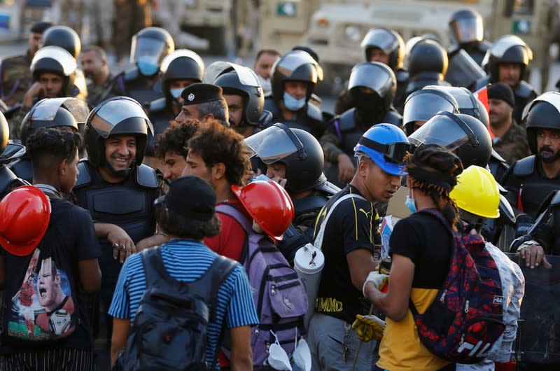 Riot police stand at Al Shuhada bridge during ongoing anti-government protests, in Baghdad