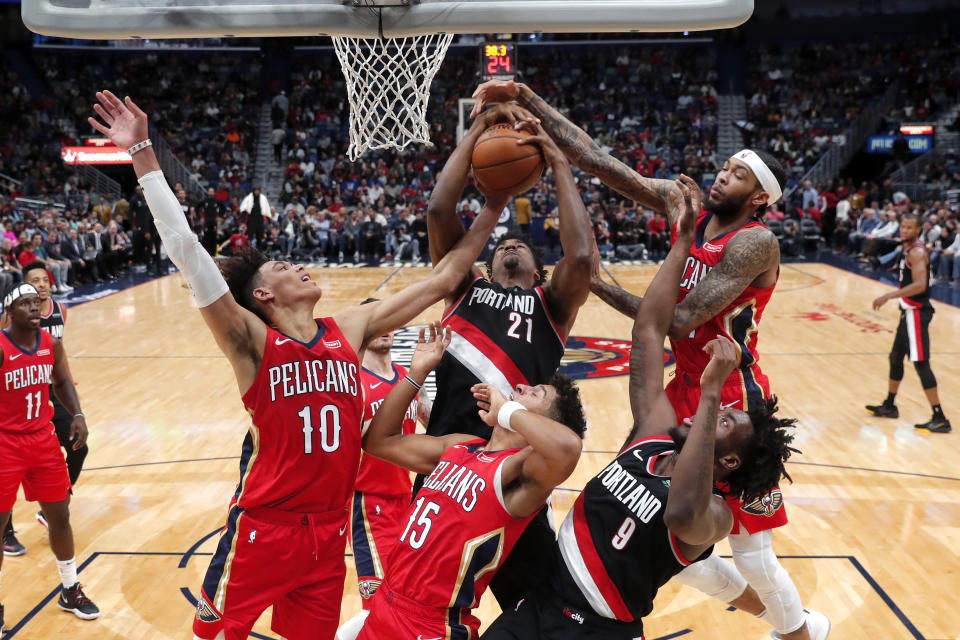 Portland Trail Blazers center Hassan Whiteside (21) pulls down a rebound over forward Nassir Little (9) and New Orleans Pelicans center Jaxson Hayes (10), guard Frank Jackson (15) and forward Brandon Ingram, right, in the first half of an NBA basketball game in New Orleans, Tuesday, Nov. 19, 2019. (AP Photo/Gerald Herbert)