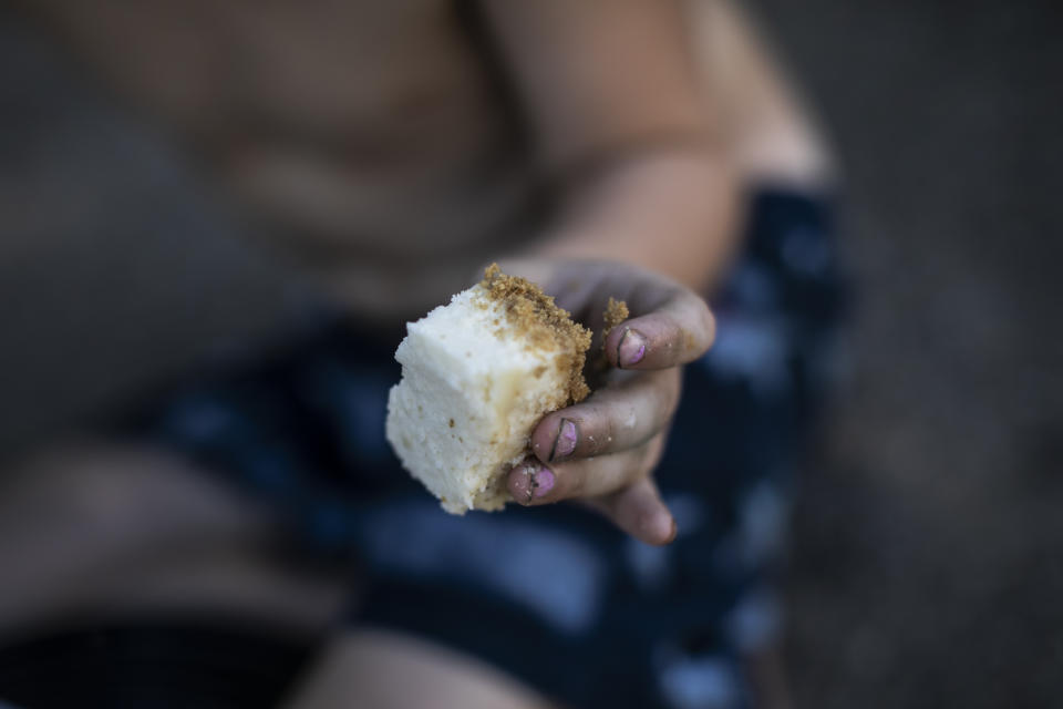 Brittany Cunningham's nephew eats a piece of cheesecake they received from a food pantry in Nelsonville, Ohio, on Friday, July 24, 2020. Brittany, a heroin addict, has been homeless for ten years. (AP Photo/Wong Maye-E)