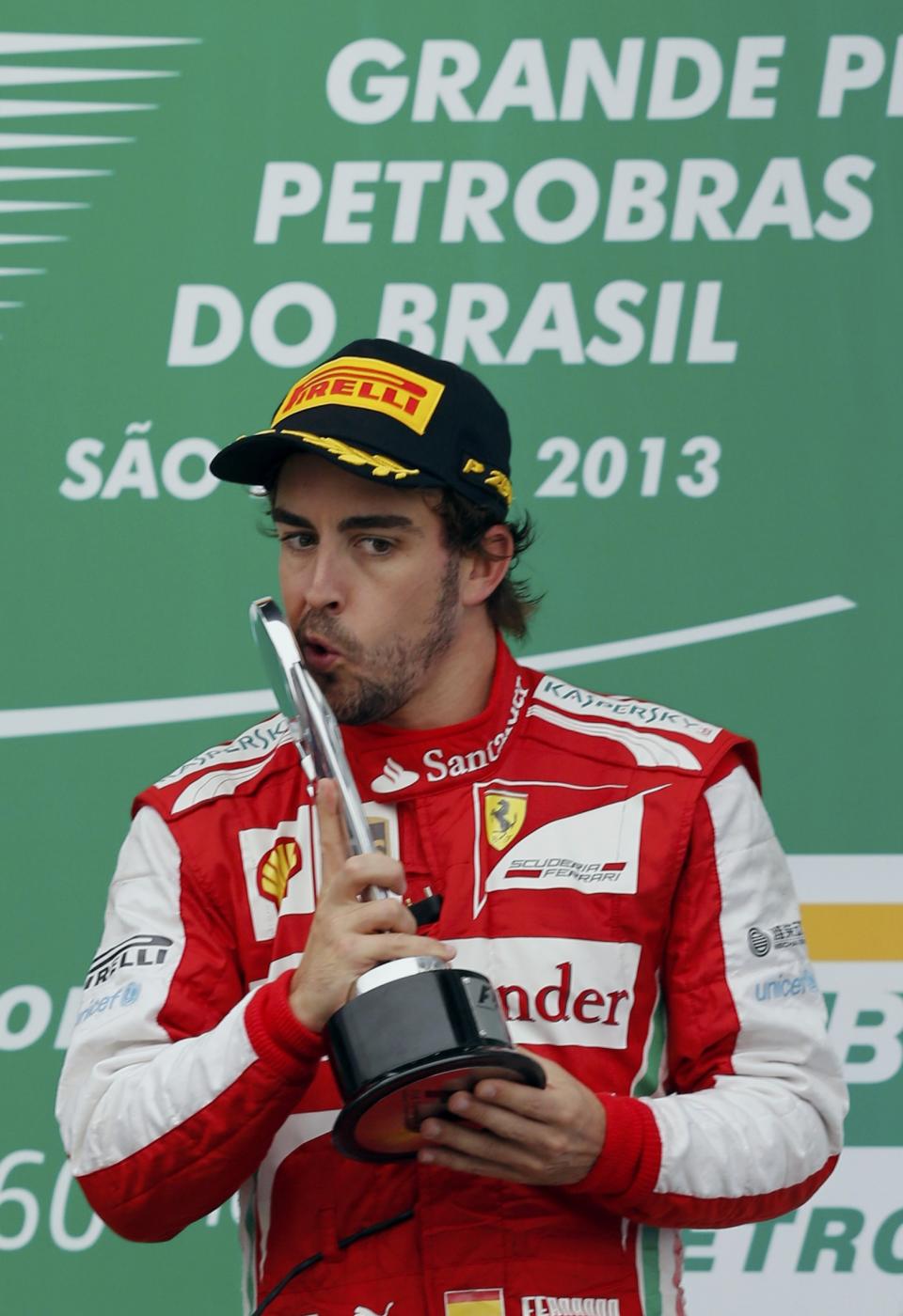 Fernando Alonso of Spain kisses the trophy during podium celebrations after the Brazilian F1 Grand Prix at the Interlagos circuit in Sao Paulo