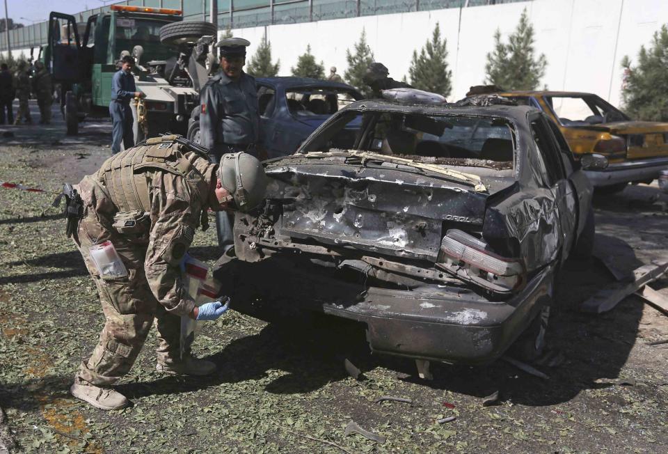 A U.S. soldier carries out an investigation at the site of a suicide attack in Kabul September 16, 2014. (REUTERS/Omar Sobhani)