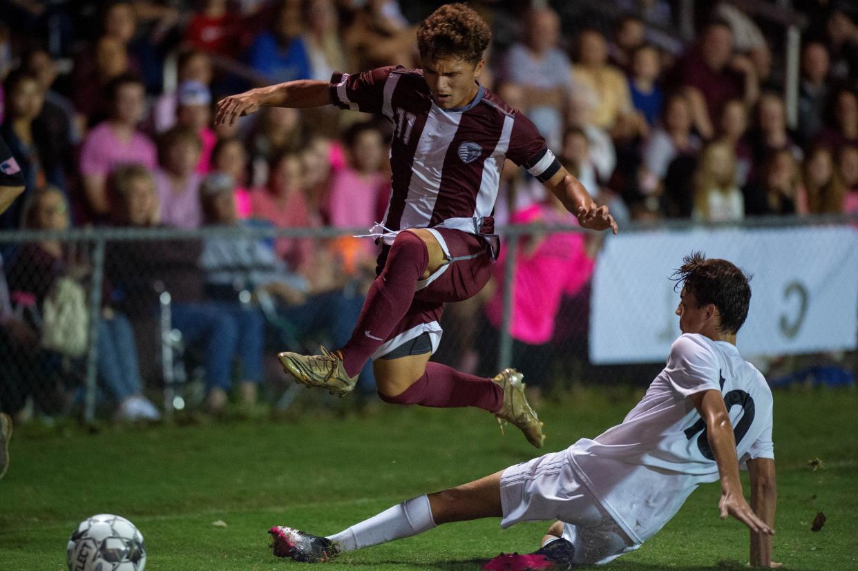 Henderson's Ashton Todd (11) hurdles Madisonville's Maverick Peyton (10) as the Henderson County Colonels face the Madisonville-North Hopkins Maroons in the 2nd Region Soccer Tournament semifinals at the Stadium of Champions in Hopkinsville, Ky., Wednesday evening, Oct. 13, 2021.