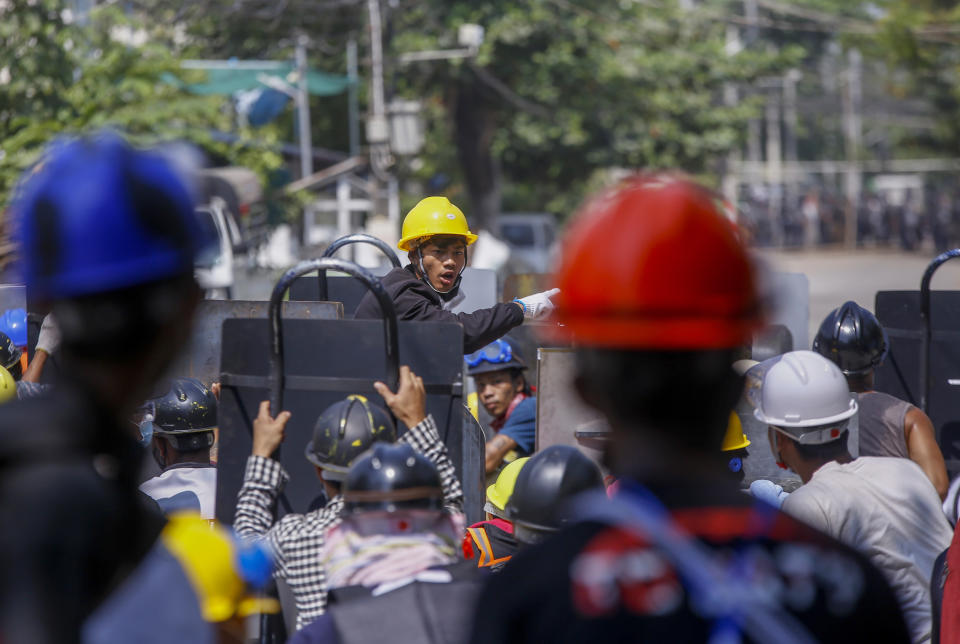 Anti-coup protesters communicate from the frontlines as they stand off with riot policemen in Yangon, Myanmar Wednesday, March 10, 2021.Security forces in Myanmar on Wednesday staged a raid at sunrise on an area of Yangon housing state railway workers, who have strongly supported the protest movement against last month’s military takeover by going on strike. (AP Photo)