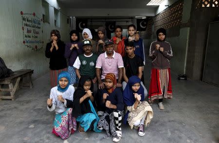 Girl trainees pose for a group photograph with their coach Yunus Qambrani and assistant coach Nadir at the first women's boxing coaching camp in Karachi, Pakistan February 20, 2016. REUTERS/Akhtar Soomro