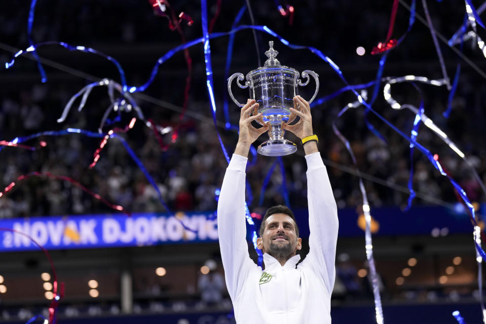 Novak Djokovic, of Serbia, holds up the championship trophy after defeating Daniil Medvedev, of Russia, in the men's singles final of the U.S. Open tennis championships, Sunday, Sept. 10, 2023, in New York. (AP Photo/Manu Fernandez)