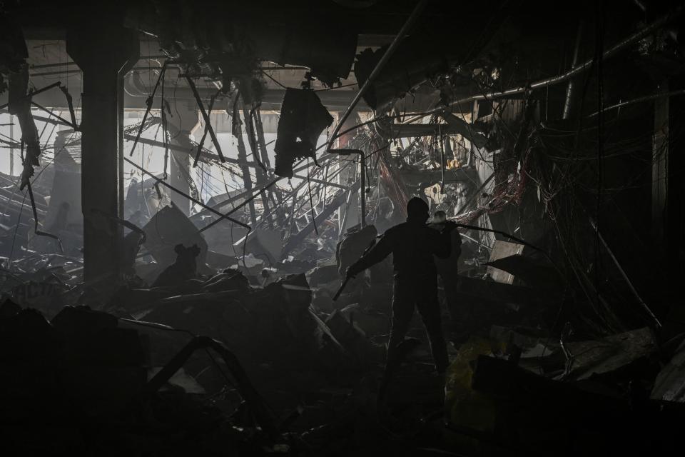 A Ukranian serviceman walks between debris inside the Retroville shopping mall after a Russian attack on the northwest of the capital Kyiv on March 21, 2022. - At least six people were killed in the overnight bombing of a shopping centre in the Ukrainian capital Kyiv, an AFP journalist said, with rescuers combing the wreckage for other victims. The 10-storey building was hit by a powerful blast that pulverised vehicles in its car park and left a crater several metres (yards) wide. (Photo by ARIS MESSINIS / AFP) (Photo by ARIS MESSINIS/AFP via Getty Images)