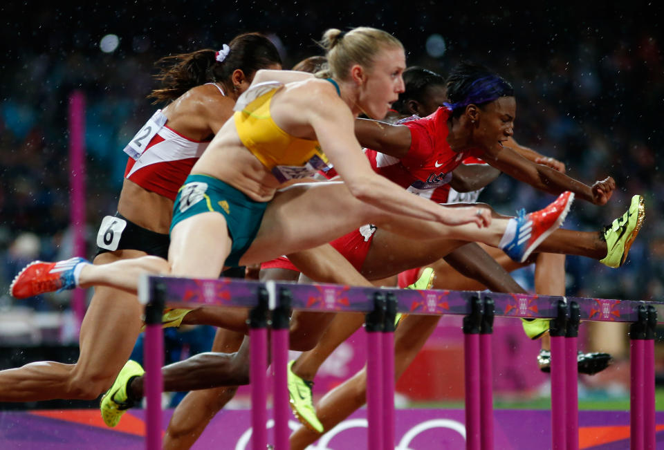 LONDON, ENGLAND - AUGUST 07: Sally Pearson of Australia leads Nevin Yanit of Turkey and Kellie Wells of the United States during the Women's 100m Hurdles Final on Day 11 of the London 2012 Olympic Games at Olympic Stadium on August 7, 2012 in London, England. (Photo by Jamie Squire/Getty Images)