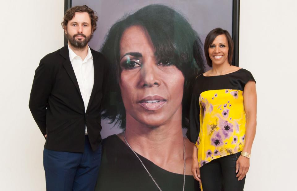 Craig Wylie posa con una de sus obras que pintó de la atleta Kelly Holmes (D), en su estudio en Londres.