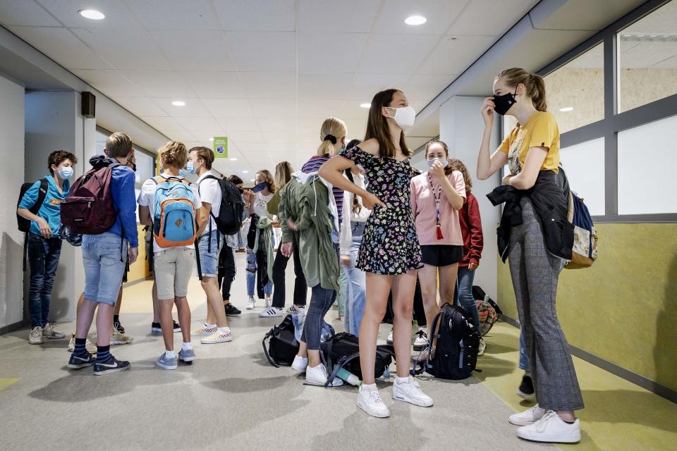 Students wear protective facemasks as they arrive for their first day of school in the Netherlands. (Photo by ROBIN VAN LONKHUIJSEN/ANP/AFP via Getty Images)