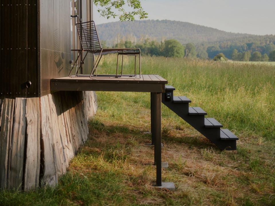 Stairs leading up to a black Raus cabin.