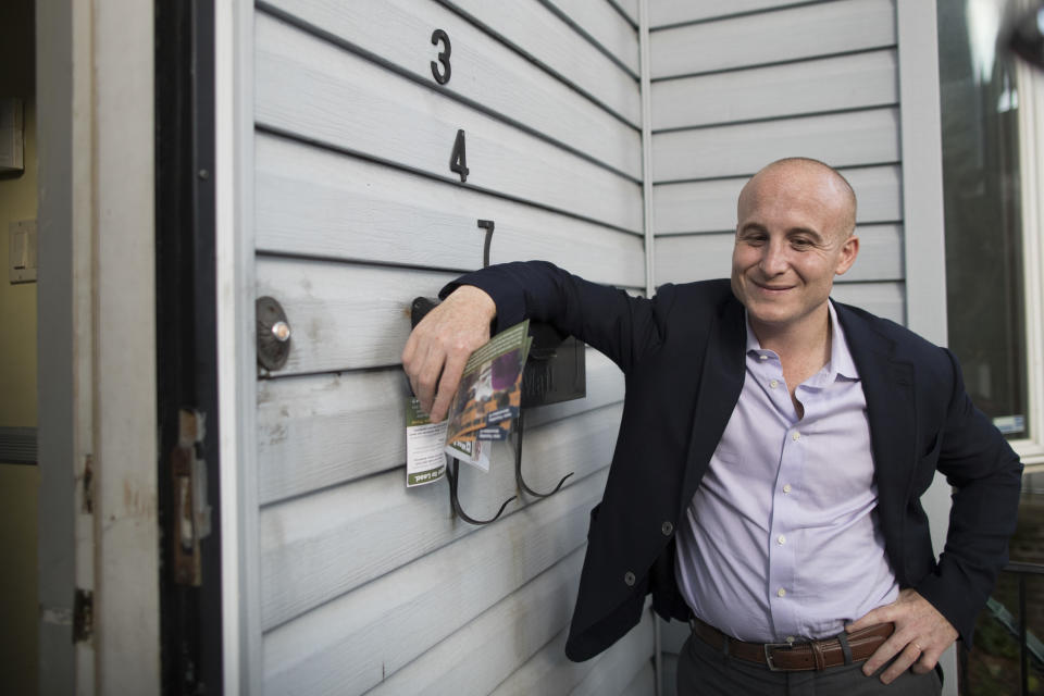 In this Wednesday, Oct. 3, 2018 photo, Democratic congressional candidate Max Rose smiles while speaking to Demetra Decolvenaere while canvassing in the Bay Ridge neighborhood of the Brooklyn borough of New York. The Army veteran who is targeting Rep. Dan Donovan, the only Republican Congress member from New York City, is part of a wave of Democrats with military experience running in the Nov. 6, 2018 midterm elections. (AP Photo/Mary Altaffer)