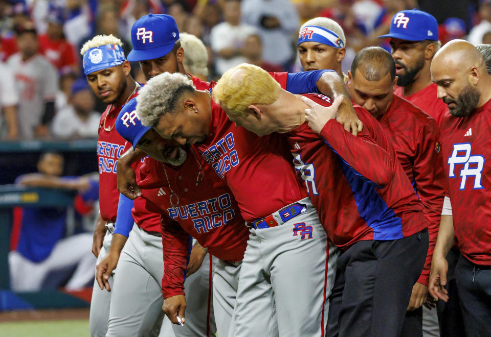 Puerto Rico pitcher Edwin Diaz (39) is being helped by team pitching coach Ricky Bones and medical staff after the the Pool D game against Dominican Republic at the World Baseball Classic at loanDepot Park on Wednesday, March 15, 2023, in Miami. (David Santiago/Miami Herald via AP)