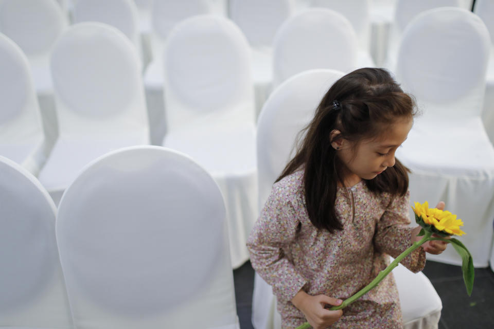 A girl holds a flower as friends and family of victims from Malaysia Airlines Flight MH17 plane crash attend a ceremony marking the fifth anniversary of the tragedy in Kuala Lumpur, Malaysia, Wednesday, July 17, 2019. Five years after a missile blew Malaysia Airlines Flight 17 out of the sky above eastern Ukraine, relatives and friends of those killed gathered Wednesday in Kuala Lumpur and at a Dutch memorial to mark the anniversary. (AP Photo/Vincent Thian)