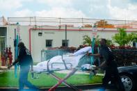 Emergency Medical Technicians (EMT) leave with a patient at North Shore Medical Center where the coronavirus disease (COVID-19) patients are treated, in Miami