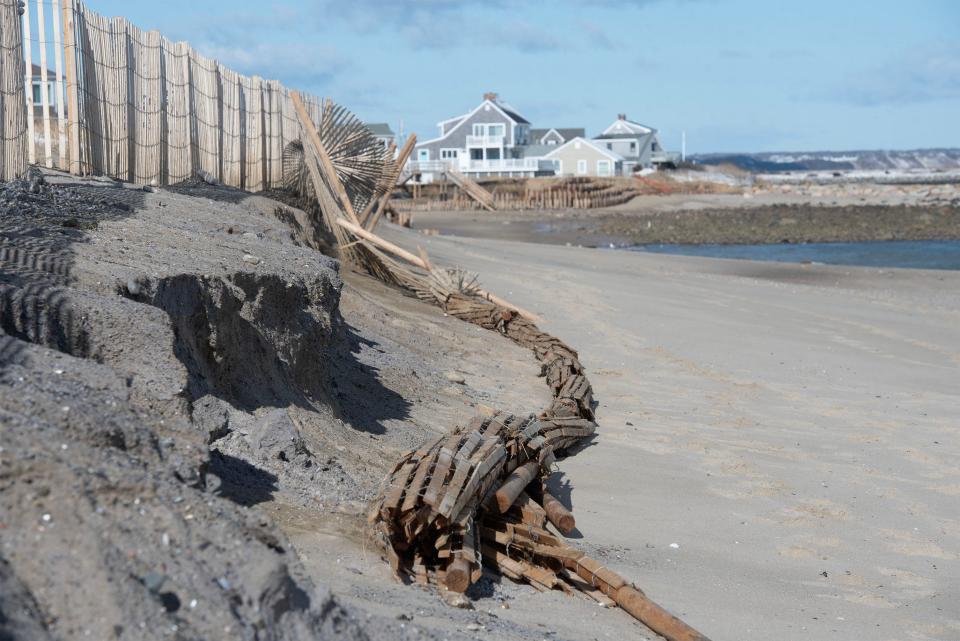 Protective fencing dangles along a section of Town Neck Beach in Sandwich as the newly reinforced dune suffered erosion during a Feb. 13 storm tide. A new dredging project, creating a new dune, is expected to kick off in October.