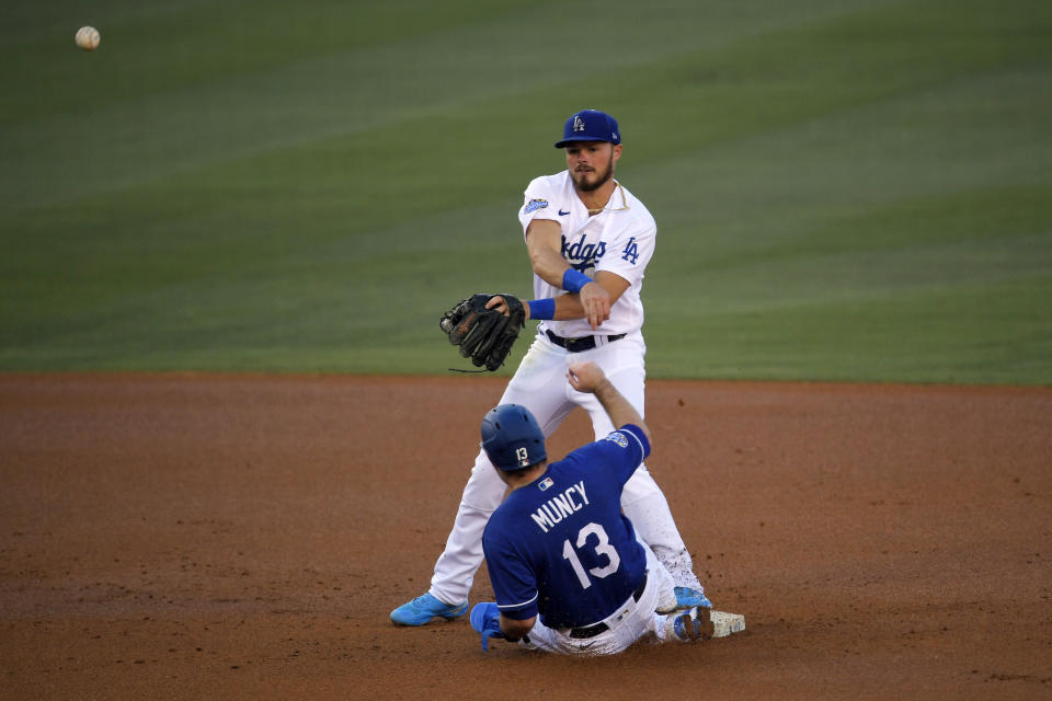 Los Angeles Dodgers' Max Muncy, below, is forced out at second asGavin Lux attempts to throw out A.J. Pollock at first during an intrasquad baseball game Wednesday, July 15, 2020, in Los Angeles. Pollock was safe at first. (AP Photo/Mark J. Terrill)