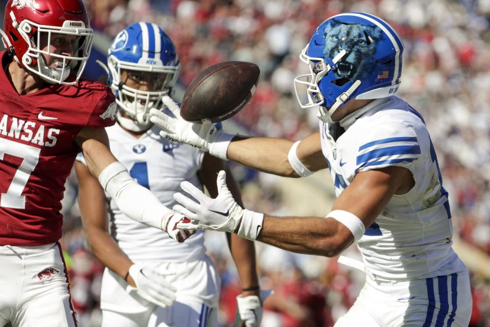 BYU receiver Puka Nacua juggles the ball in the end zone to score a touchdown against the Arkansas Razorbacks in Provo.