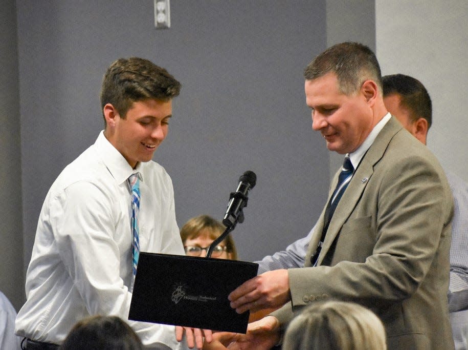 Tecumseh High School student Andrew Rowe, left, is one of 82 high school juniors and seniors who were inducted April 6 into the Lenawee Intermediate School District's chapter of the National Technical Honor Society. Rowe is congratulated by LISD Superintendent Mark Haag during the induction ceremony.