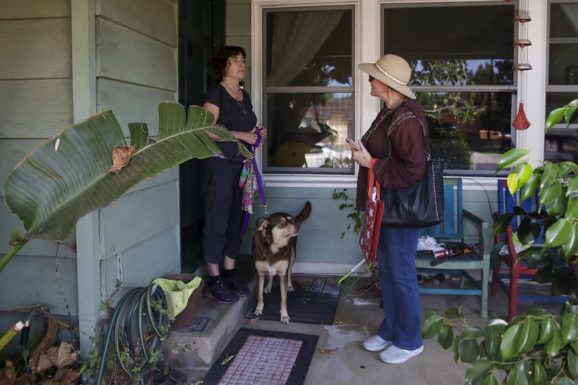 Los Angeles, CA - October 08: Volunteer Trisha Dexter, right, talks to a resident Amira Saunders while campaigning door to door for Karen Bass in Van Nuys on Saturday, Oct. 8, 2022 in Los Angeles, CA. (Irfan Khan / Los Angeles Times)