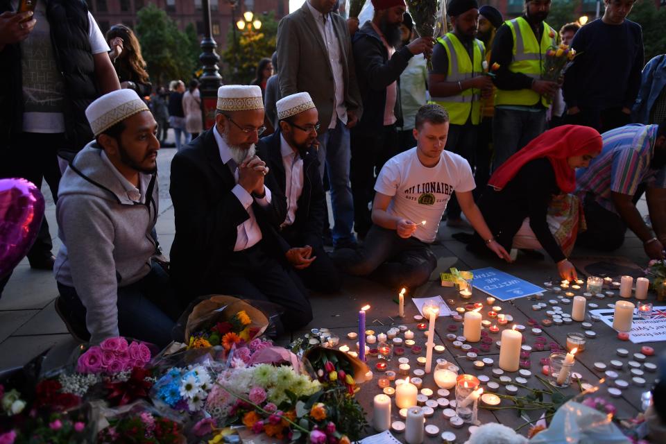 People pray and light candles in Albert Square in Manchester.