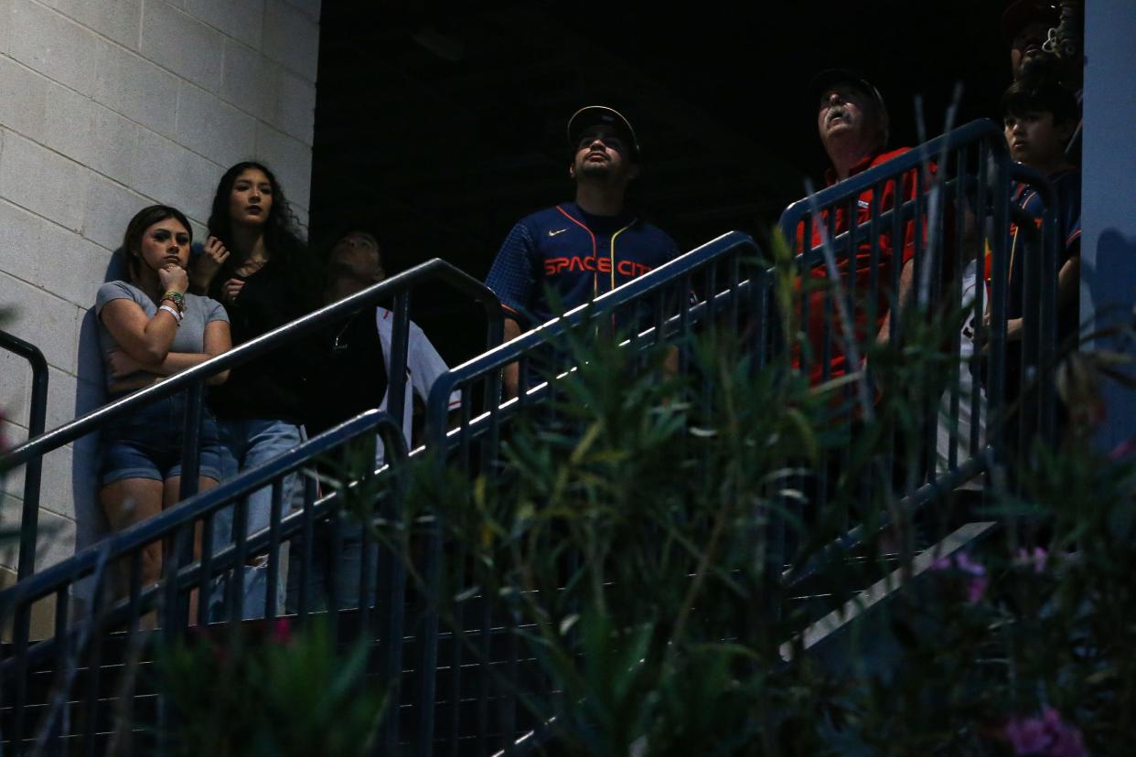 People congregate at the top of a stairwell at Whataburger Field during a Hooks game to look at a crane that caught fire while working the new Harbor Bridge project on Saturday, April 22, 2023, in Corpus Christi, Texas.