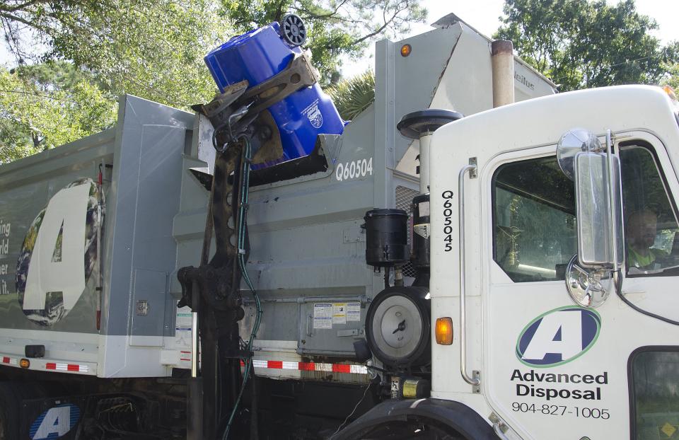 A mechanical arm dumps a 95-gallon recycling container into an Advanced Disposal truck in this 2015 photo.