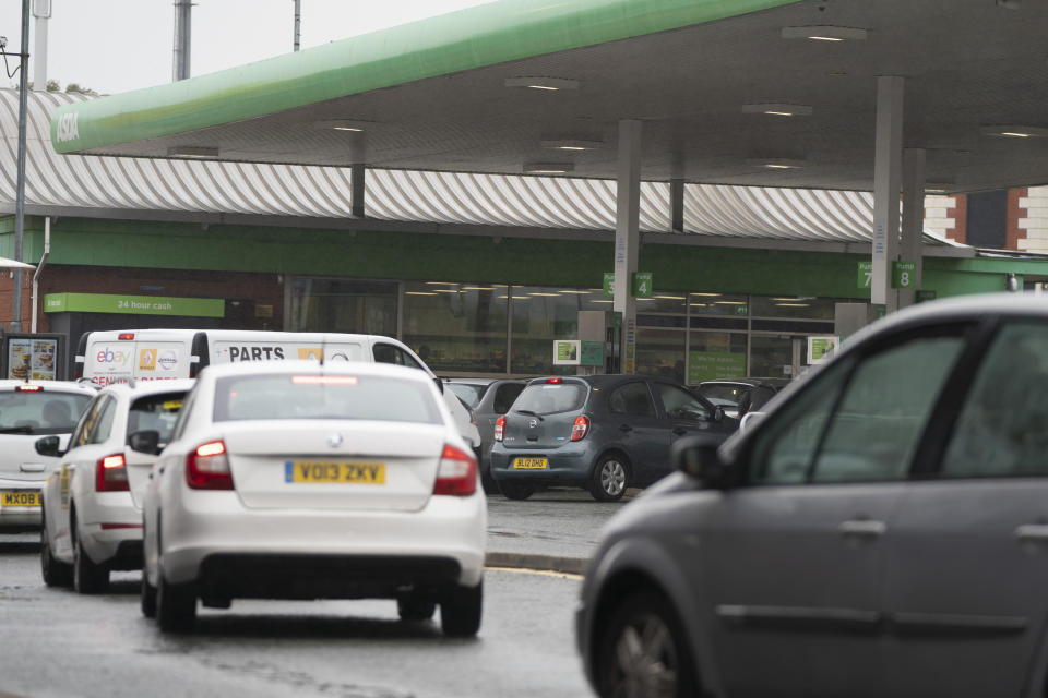 Vehicles wait to fill up at a petrol station in Manchester, England, Monday, Sept. 27, 2021. British Prime Minister Boris Johnson is said to be considering whether to call in the army to deliver fuel to petrol stations as pumps ran dry after days of panic buying. ( AP Photo/Jon Super)