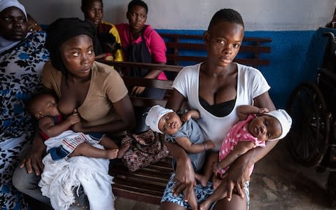 Augustina Korley, 13, with her one-month-old twins Senior and Junior - Credit: Simon Townsley/The Telegraph