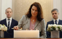 Sweden's Ann Linde, Minister of Foreign Affairs lights a candle in front of a plaque with the names of the victims of flight PS752, at the High Commission of Canada in London, Thursday, Jan. 16, 2020. The Foreign ministers gather in a meeting of the International Coordination and Response Group for the families of the victims of PS752 flight crashed shortly after taking off from the Iranian capital Tehran on Jan. 8, killing all 176 passengers and crew on board.(AP Photo/Frank Augstein)