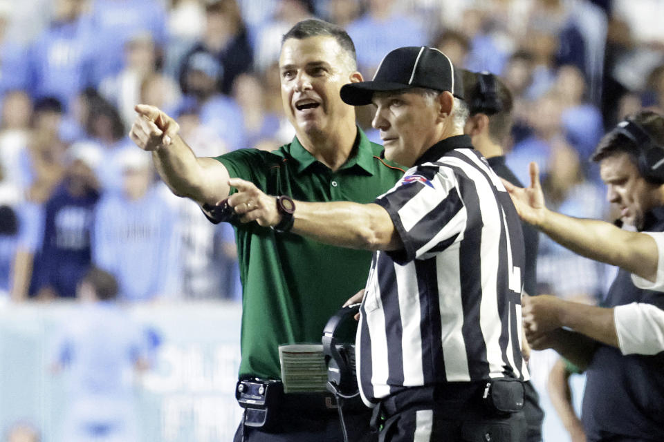 Miami head coach Mario Cristobal discusses a call with an official during the first half an NCAA college football game against North Carolina, Saturday, Oct. 14, 2023, in Chapel Hill, N.C. (AP Photo/Chris Seward)