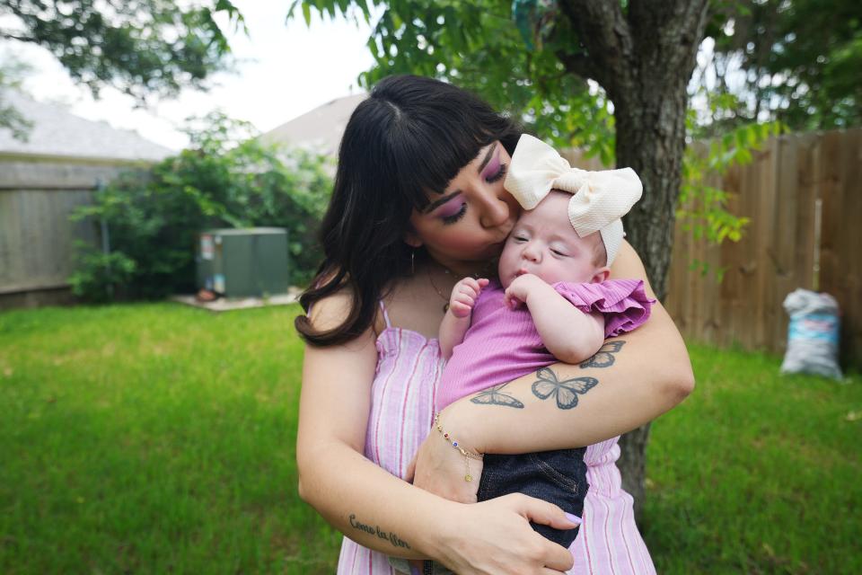 Luci Hanson holds daughter Violet in her backyard in Pflugerville. On this Mother's Day, the mom is grateful to her doctors for doing an operation to allow her daughter more time before birth because of a complication with Luci's cervix.