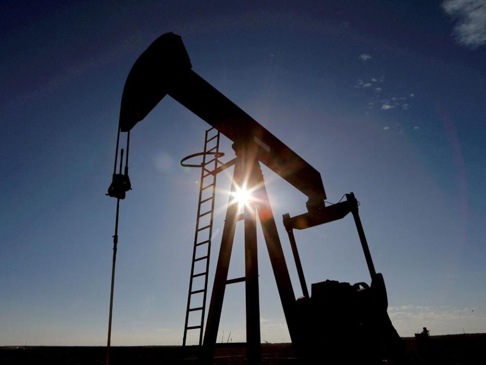 FILE PHOTO: The sun is seen behind a crude oil pump jack in the Permian Basin in Loving County