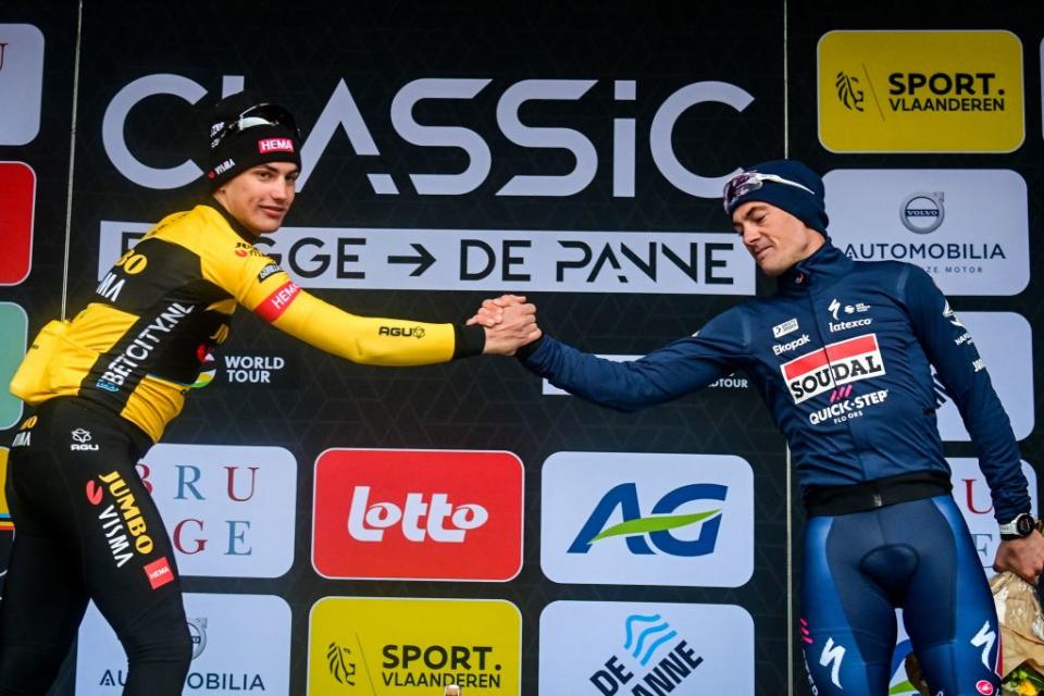 JumboVismas Dutch rider Olav Kooij L shakes hands with Soudal QuickSteps Belgian rider Yves Lampaert as they celebrate on the podium after the mens elite race of the Classic BruggeDe Panne oneday cycling race 2074km from Brugge to De Panne on March 22 2023 Photo by ERIC LALMAND  Belga  AFP  Belgium OUT Photo by ERIC LALMANDBelgaAFP via Getty Images